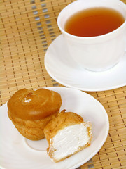 Brewing delicious cake with cream and a cup of tea