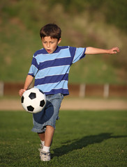 Latino boy playing with soccer ball