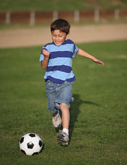 Latino boy playing with soccer ball