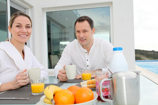Couple having breakfast in their home terrace