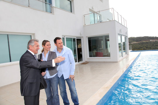 Couple visiting luxury villa with real-estate agent