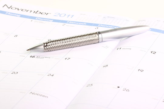 aufgeschlagener Kalender mit Stift Sommeranfang 
