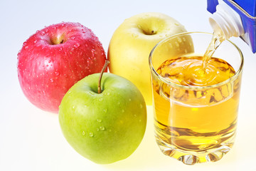 Green, red and yellow apples and glass of juice