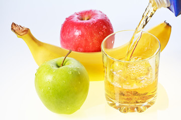 Banana, green and red apples and glass of juice