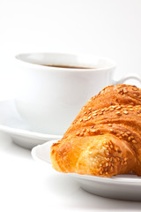 Breakfast: coffee and croissant with sesame seeds