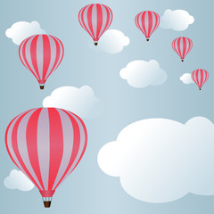 Hot air ballons among clouds in sky