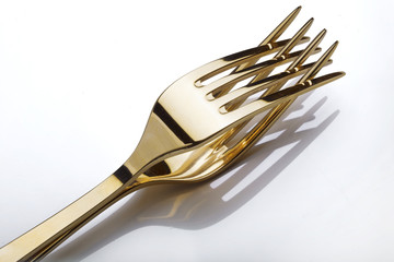 Two gold  forks isolated over white background.