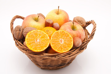 Korb mit Mandarinen, Äpfeln und Nüssen