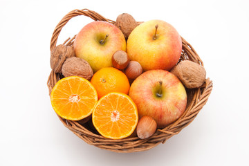 Korb mit Mandarinen, Äpfeln und Nüssen