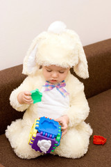 Pretty caucasian baby in rabbit costume playing
