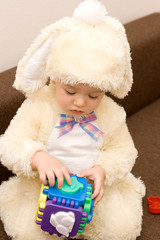 Pretty caucasian baby in rabbit costume playing