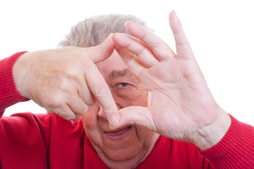 Senior schaut durch Hände