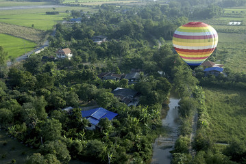 hot air balloon floating in the sky over land.