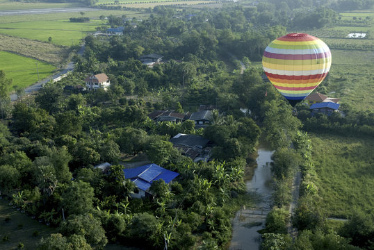 hot air balloon floating in the sky over land.
