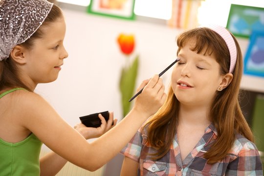 Young Girl Putting Makeup On Friend