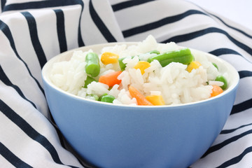 Blue bowl with cooked rice with mixed vegetable