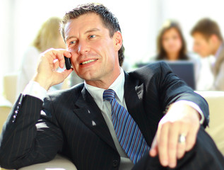 Concentrating businessman on call, coworkers talkling