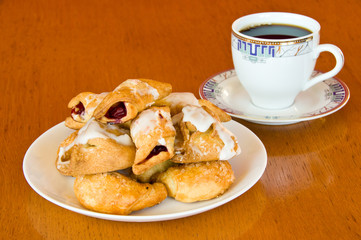 Plate of pastry and a cup of coffee on wooden table
