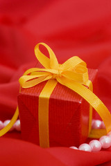 Box with a gift on a red fabric