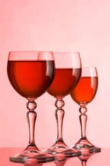 Wine glasses with wine on a pink background