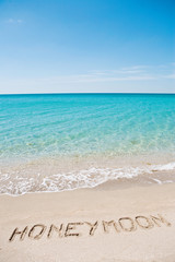 Honeymoon written on the sand