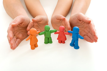 Woman and child hands protecting modeling clay people