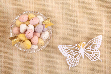 easter chocolate speckled eggs in bowl with paper batterfly on h