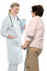 doctor or nurse talking with a senior woman on crutches