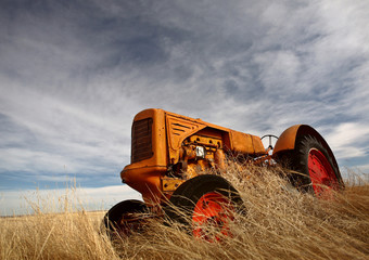 Obraz premium Tumbleweeds piled against abandoned tractor