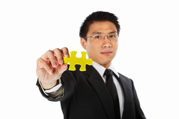 Businessman showing jigzaw puzzle piece