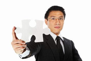 Businessman showing jigzaw puzzle piece