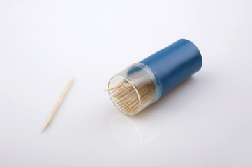 toothpicks in blue container with one aside