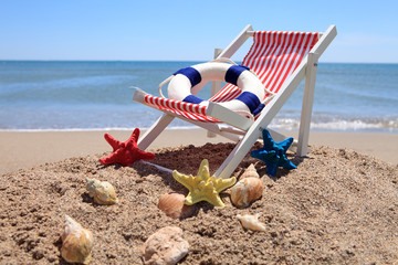 Fototapeta na wymiar Beach chair near the ocean with shells
