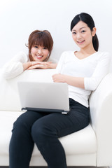 Fototapeta premium two beautiful asian women relaxing on the sofa