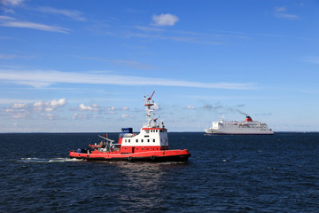 Obraz premium Fireboat on the background of a cruise ship on the seas.