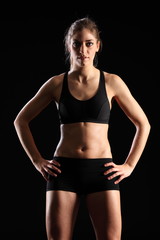 Fototapeta na wymiar Fit young woman standing in black sports outfit