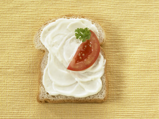 Bread top with Mayonnaise and slice of tomato.