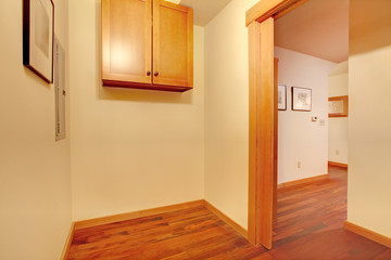 Empty laundry room with hallway and cherry hardwood floor