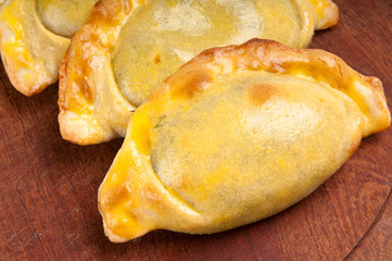 Empanadas over wooden plate