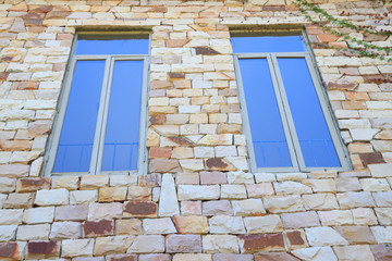 Fototapeta na wymiar Two windows on brick wall.