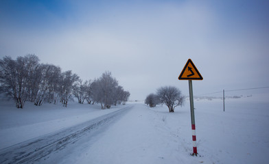 Fototapeta premium Yellow sign on a snowy road