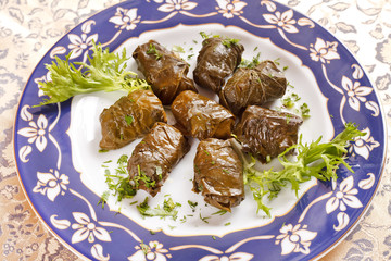 vine leaves stuffed with rice (dolmades served on a plate)