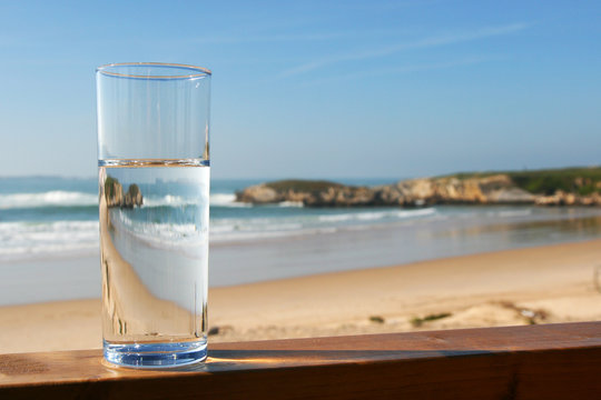 glass of water with view on beach