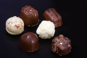 Delicious chocolates on black background