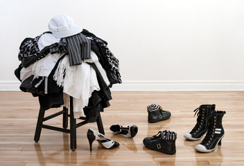 Heap of clothing on a stool and disordered shoes