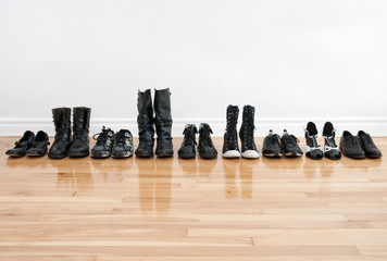 Row of shoes and boots on a wooden floor - Powered by Adobe