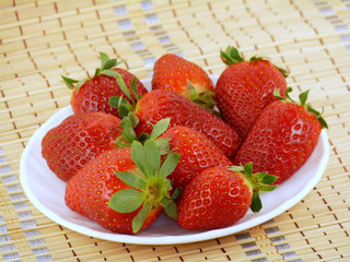 Appetizing large strawberry on a white plate