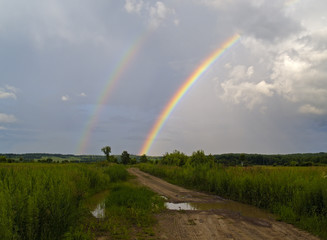 Summer landscape with road and a rainbow