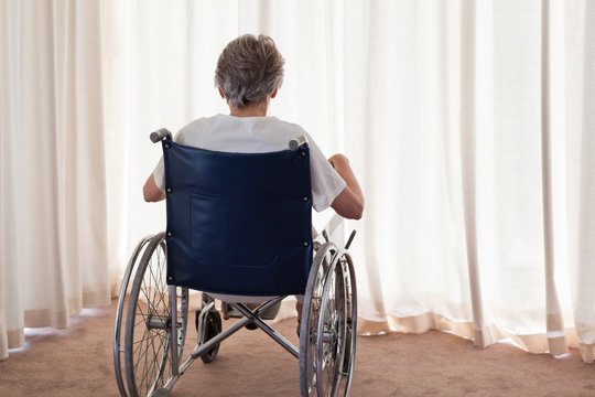 Mature Woman In Her Wheelchair With Her Back To The Camera At Ho