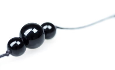 Three black balls from a beads on a white background